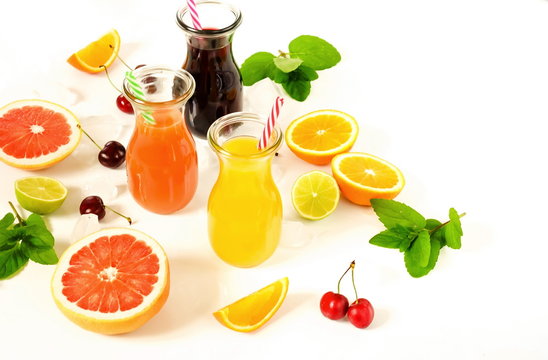 Assortment of natural juices in glass jars of oranges, grapefruit, cherries and various fruits on a white background. top view. copy space