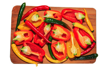 Pepper and garlic in greens on textured wooden board with copyspace