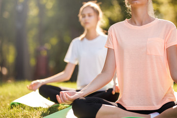 Detail of women doing yoga outdoors at sunrise. Morning meditation
