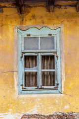 Beautiful design of an old window with broken glasses of an abandoned house in the Bulgarian Fore-Balkan village of Debnevo