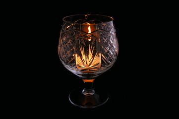 Crystal glass with a lit candle inside.