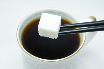 Cup of tea and sugar on sticks.