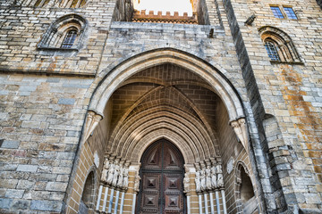 Wooden door on brick wall church in Evora Portugal