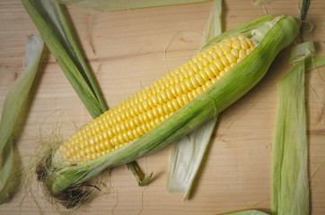 Fresh corn on cob on wooden table, closeup.