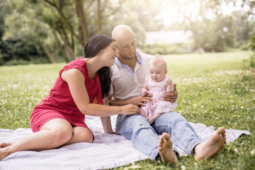 Fototapeta premium Happy family with Baby girl lay on a blanket