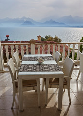 Fototapeta na wymiar Restaurant at edge of cliff near blue sea in Konyaalti district of popular resort city Antalya, Turkey.