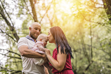 Fototapeta premium Father Mother and daughter baby in summer meadow park