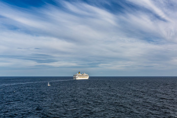 Obraz premium Big ferry and small sailing ship in the sea