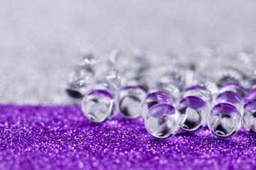 Hydrogel ball rotating on purple and silver surface. Close up macro.