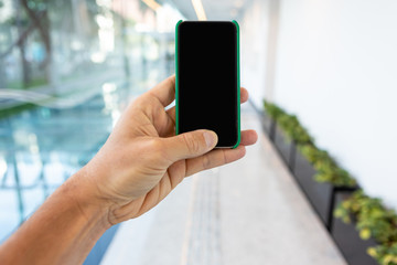 Close up of mobile phone with corporate environment blurred in the background.