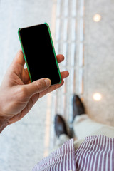 Close up of mobile phone with corporate environment blurred in the background.