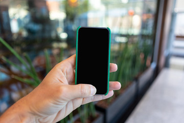 Close up of mobile phone with corporate environment blurred in the background.