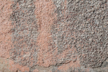 surface of the old wall with exfoliating and falling off paint as a background, pink texture