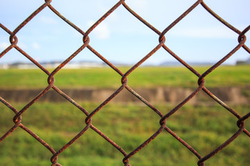 Fototapeta premium Chain link fence with grass field Phuket International Airport