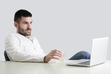 Studio portrait of young handsome businessman having a drink after work hours
