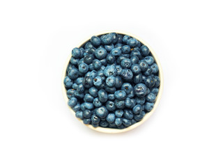 Fresh sweet blueberry in a bowl isolated on a white background, top view. Vaccinium corymbosum, the northern highbush blueberry. Close-up swamp huckleberry blue-black berry
