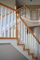 Interior staircase of home with newel post and white spindles