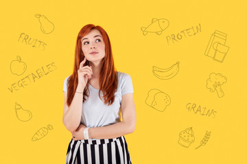 Fototapeta premium Smiling vegetarian. Positive relaxed vegetarian smiling and feeling good while thinking about going to the market and buying fresh fruit and vegetables