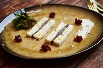 Brie cheese with truffle and jelly barberry. Delicious dish with champignons mushrooms and truffle oil at the restaurant table. Vegetarian delicacy diet food