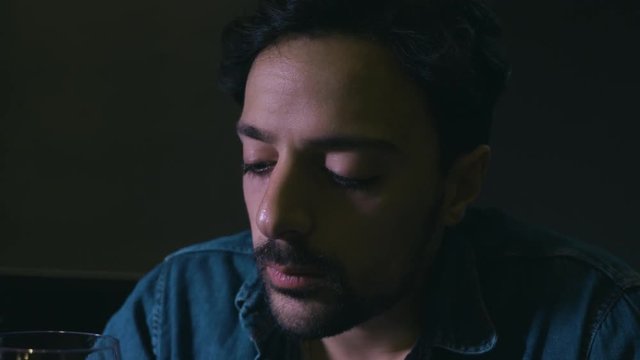 alcoholism, addiction. Depressed man drinks wine alone in the darkness