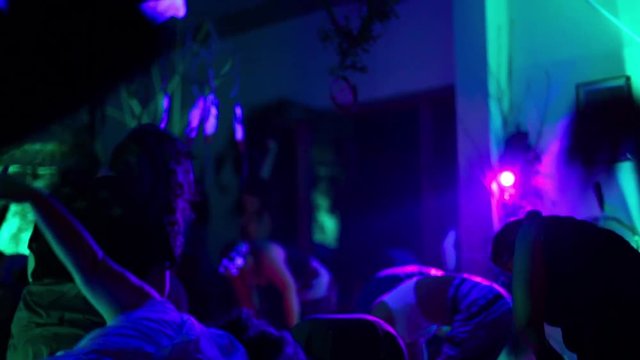 Group of women doing yoga inside, under blacklight