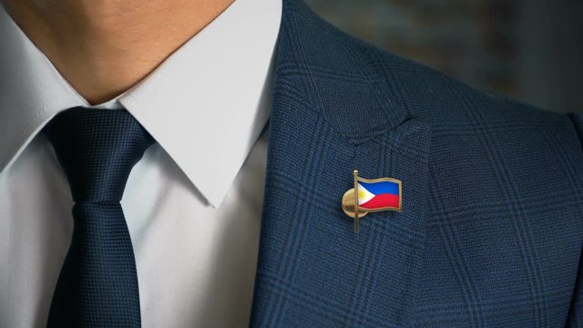 Businessman Walking Towards Camera With Country Flag Pin - Philippines