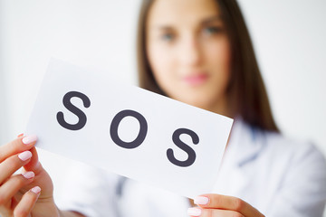 Health Care. Doctor Holding a Card With Symbol SOS, Medical Concept