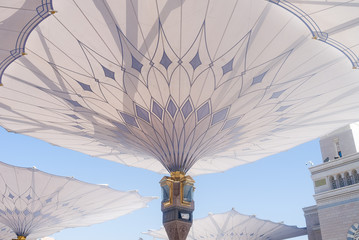 MEDINA, SAUDI ARABIA - APRIL 28 2018: These Umbrella construction on the square of Al-Masjid An-Nabawi or Prophet Muhammed Mosque are protecting people from sun at daytime and work as lights at night