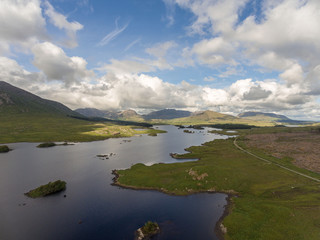 Fototapeta na wymiar Aerial birds eye scenic view from Connemara National Park in County Galway, Ireland. Beautiful Irish rural nature countryside landscape with mountains in the distance.