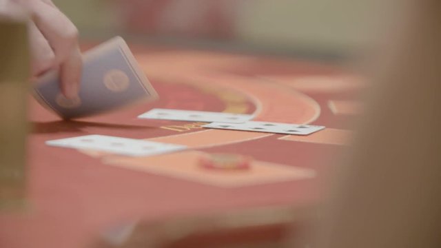Slow motion shot of cards and chips on velvet poker table in casino. Gambling, luck and addiction concept.