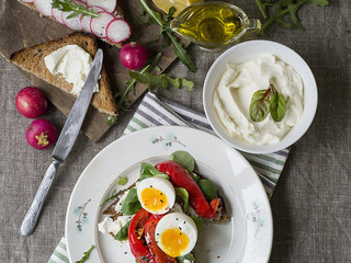Toast with egg, red pepper, cheese and rucola on a white plate. Breakfast. Background made of linen cloth. Close up. Top view