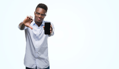 Young african american man using smartphone with angry face, negative sign showing dislike with thumbs down, rejection concept
