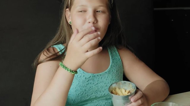 fat girl eagerly eating a French fries, concept of a healthy diet