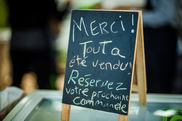 Sign that says "Thank you, everything has been sold" in a french farmer's market