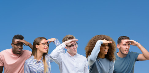 Composition of group of friends over blue blackground very happy and smiling looking far away with hand over head. Searching concept.