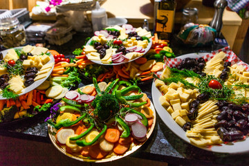 Food platters full of fresh vegetables, cheeses, sprouts and dates