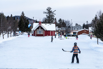 Kids playing ice hockey at the park in Val-David, Quebec, Canada
