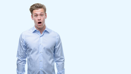 Young handsome blond man scared in shock with a surprise face, afraid and excited with fear expression