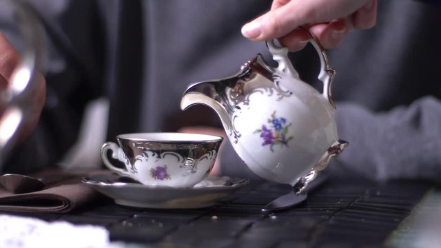 woman hand pouring milk in a cup of espresso- slow motion- close up