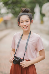 Portrait of asian woman is a professional photographer with mirrorless camera, outdoor portrait.