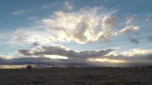 Timelapse ZOOM IN, Thick clouds roll across the rising sun over a grassland prairie