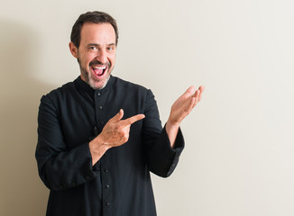 Senior priest religion man very happy pointing with hand and finger