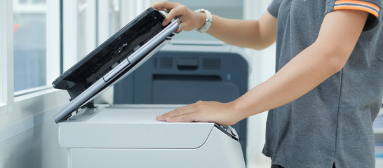 Bussiness woman Hand putting a document paper into printer scanner or laser copy machine in office