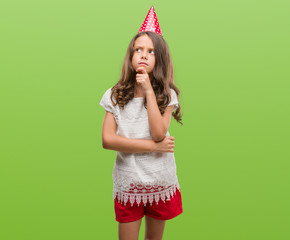 Brunette hispanic girl wearing birthday hat serious face thinking about question, very confused idea