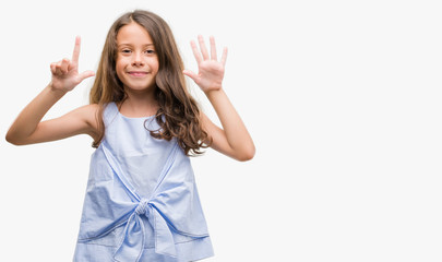 Brunette hispanic girl showing and pointing up with fingers number seven while smiling confident...