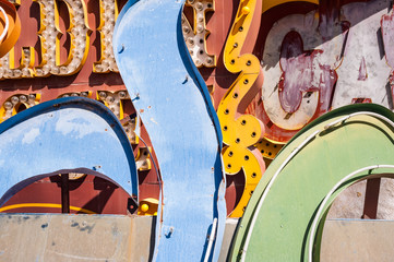 Close-up details of old signs with vintage light bulbs, metal letters and peeling paint. Colorful abstract signage, painted details and complex textures, copy space.