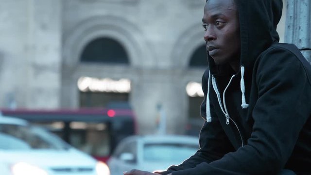 Thoughtful sad lonely black african man alone in the street
