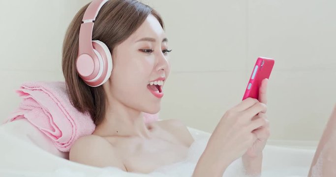 woman listen music in bathtub