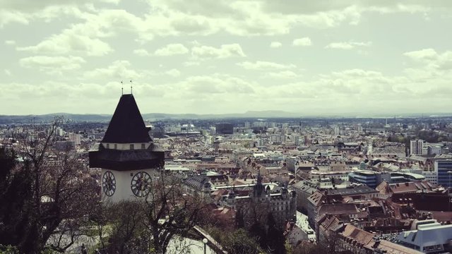 4k time lapse video of clouds over a city with an old tower.