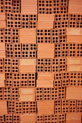 Stack of red clay construction bricks vertical background